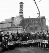 Рабочие на фоне недостроенного бетонного саркофага над Чернобыльским реактором