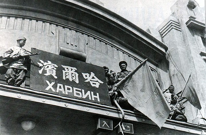 Советские бойцы водружают флаг над зданием вокзала. Харбин